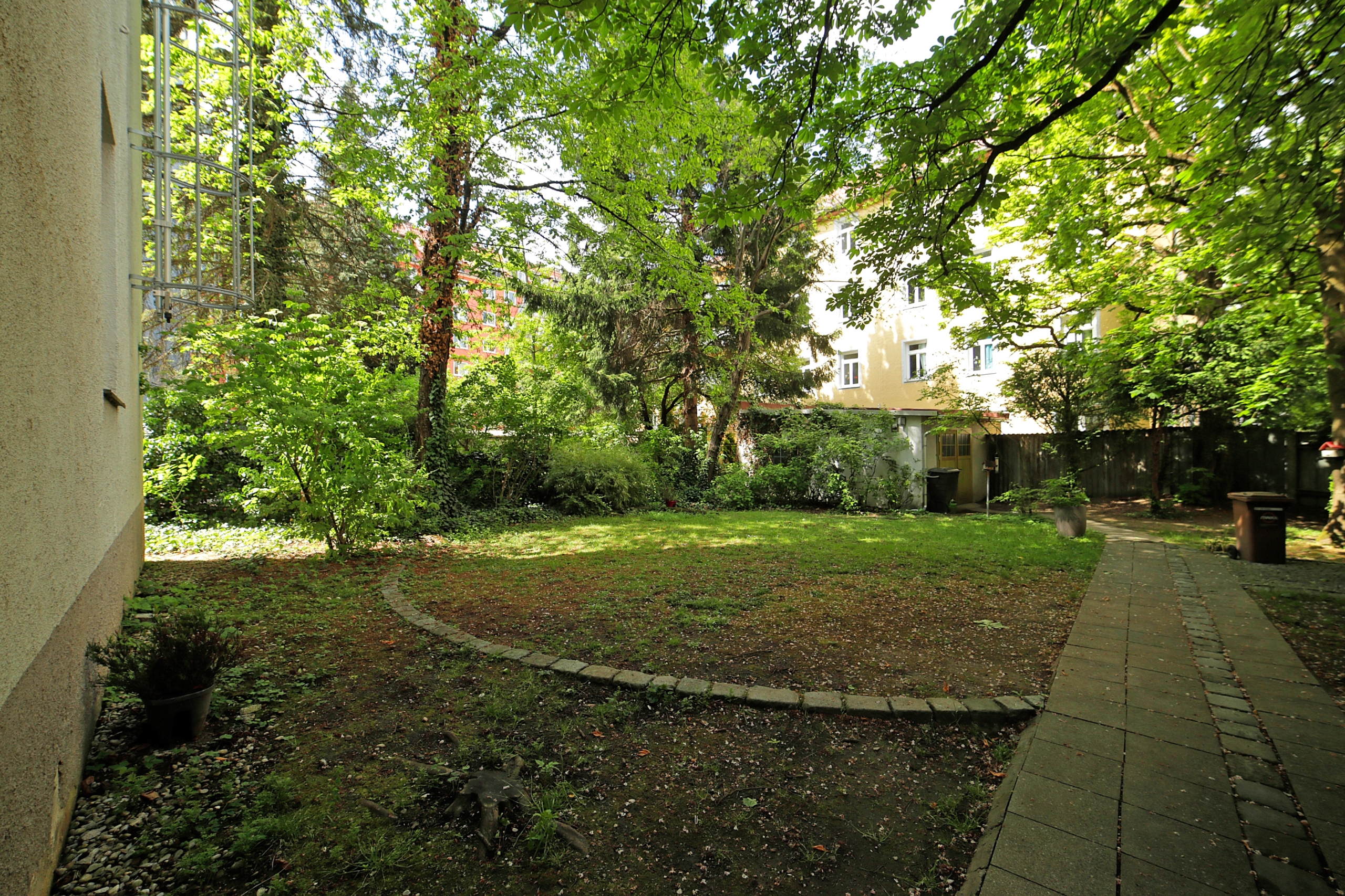 idyllischer grüner Innenhof mit altem Baumbestand